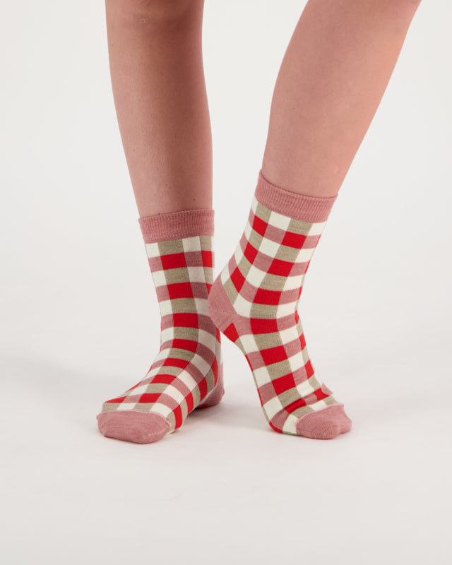 person wearing merino ankle length nisa socks in pink check