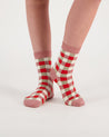 person wearing merino ankle length nisa socks in pink check